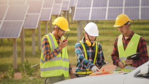 Contracotrs in front of solar panels