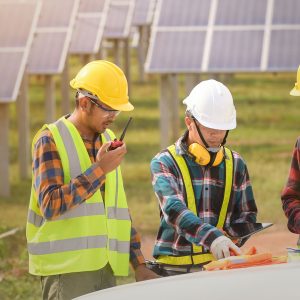 Contracotrs in front of solar panels