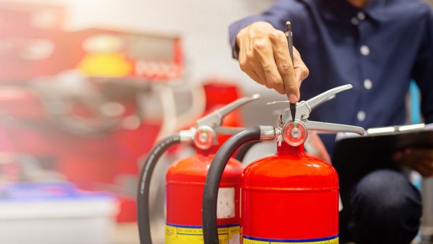 Image of a contractor working on fire extinguisher