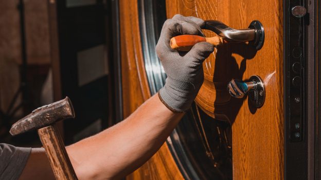 Image of a contractor working on a lock of a door