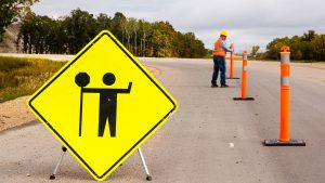 Image of a contractor on a road with road signs