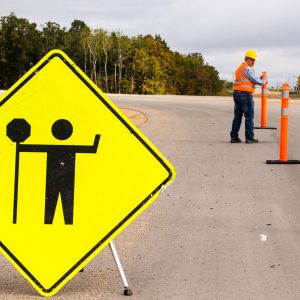 Image of a contractor on a road with road signs