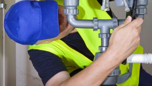 Image of man working on a pipe