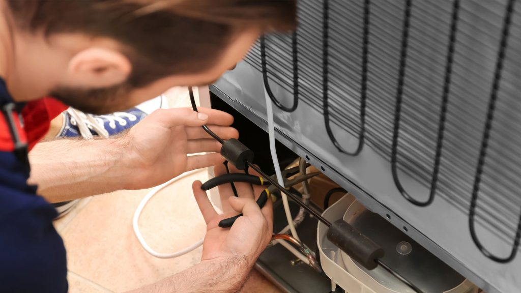 Image of man working on a refrigerator