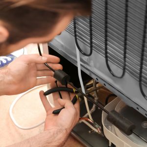 Image of man working on a refrigerator