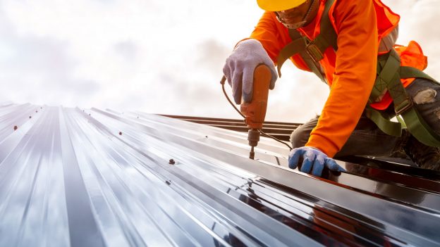 Image of a contractor working on a metal sheet