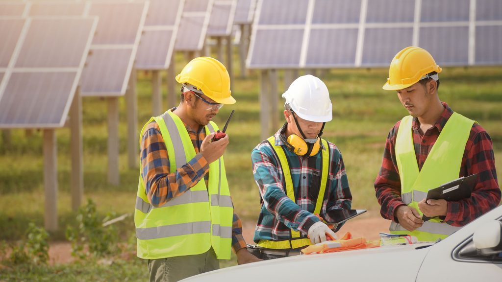 Image of three contractors working on solar panels